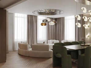 A modern dining area with a round table and green upholstered chairs, a white sofa, and a decorative ceiling light fixture. - Donatello Boutique Hotel (Almaty)