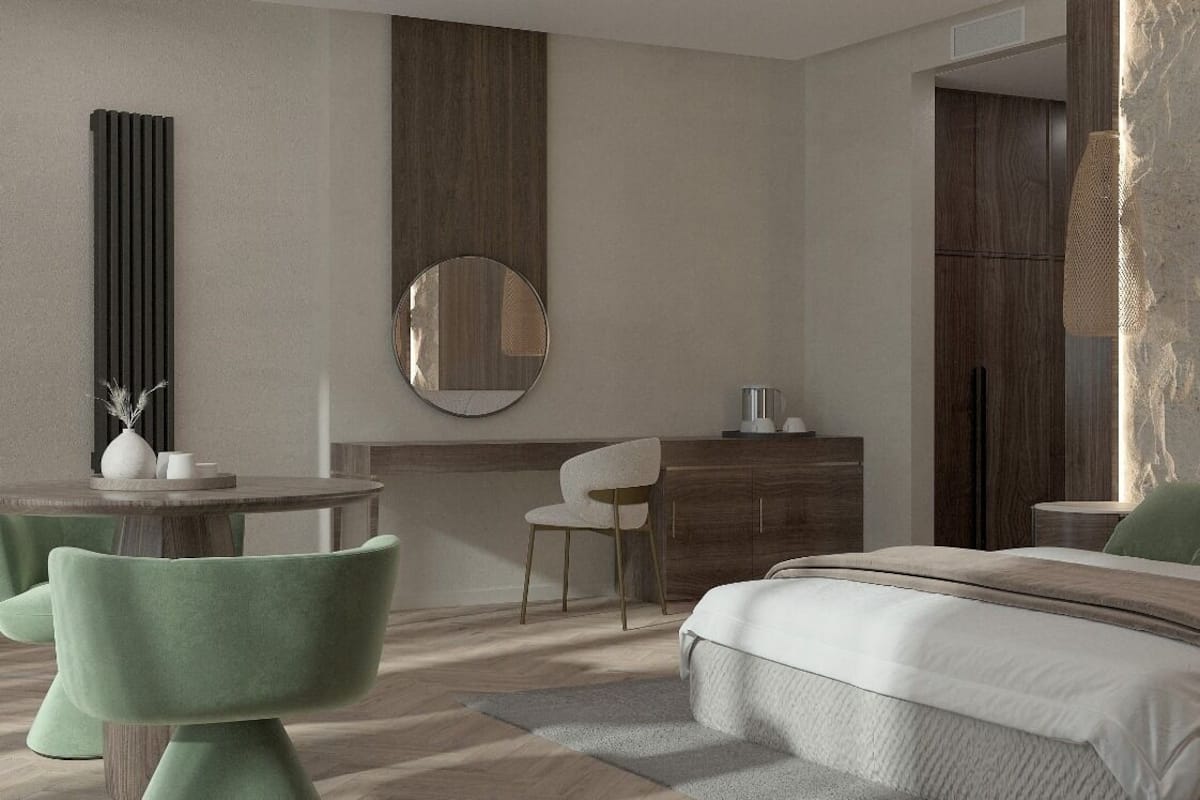 A modern bedroom with a bed, a round mirror, a dresser, and a seating area with chairs.
