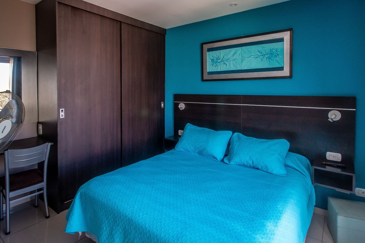 Ein Schlafzimmer mit einem großen Bett, einem Schreibtisch und einem Kleiderschrank.