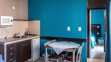 Frigorífico pequeño, microondas, placa de cocina y utensilios de cocina