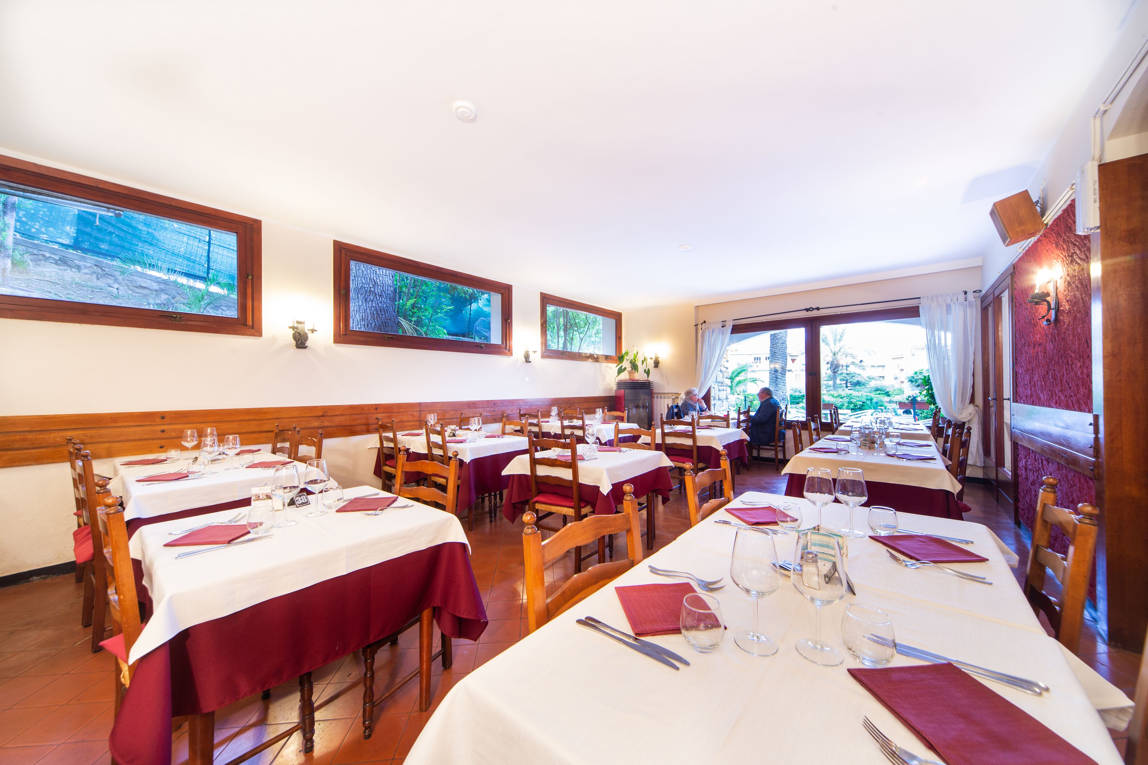 Ein Restaurant mit mehreren gedeckten Tischen, Holzkästen und weißen Tischdecken.