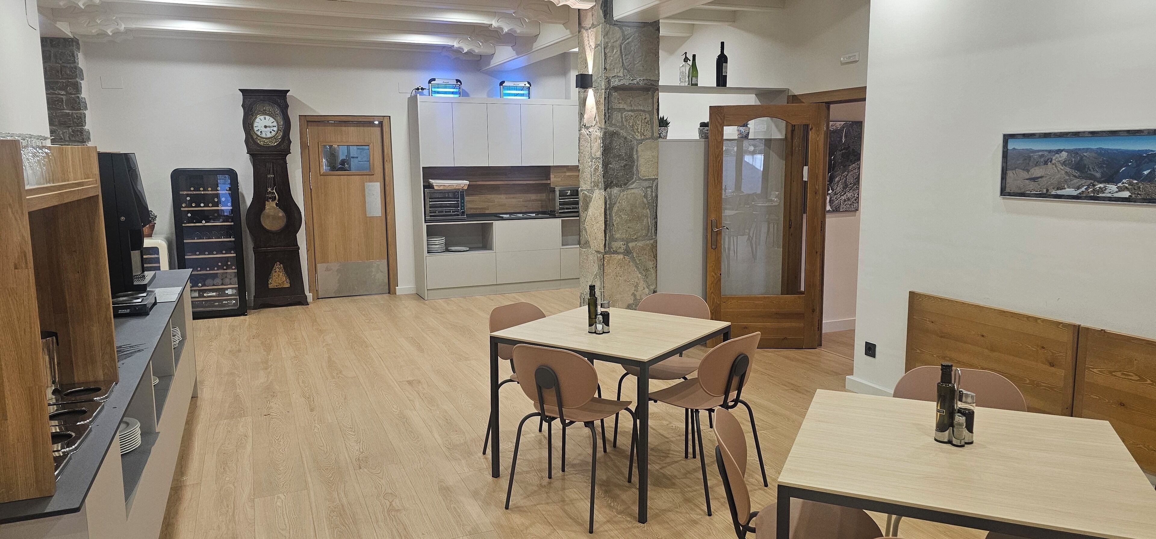 A modern kitchen with wooden cabinets, a built-in wine rack, and a dining area with a table and chairs.