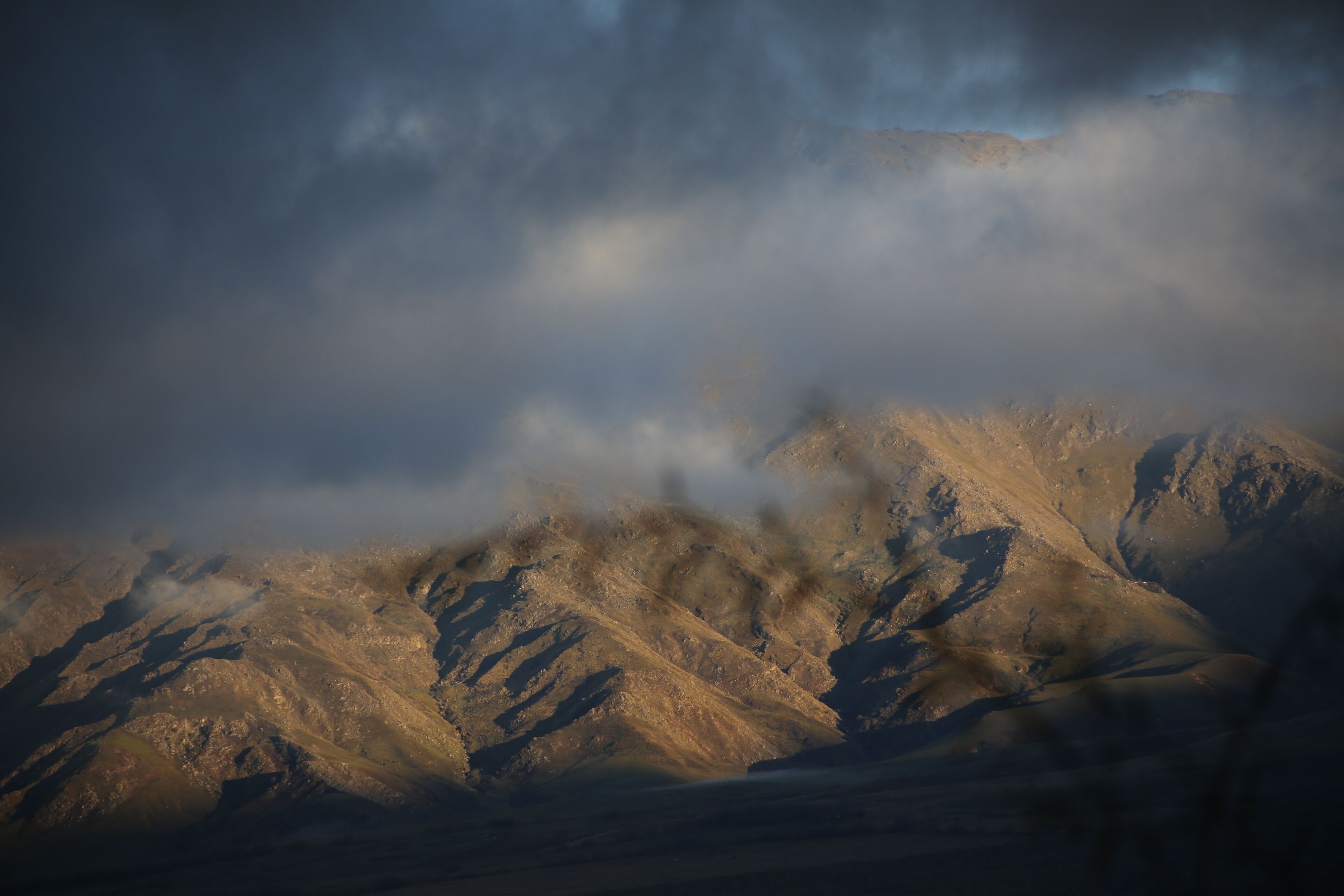 A mountainous landscape with rugged terrain and a cloudy sky.
