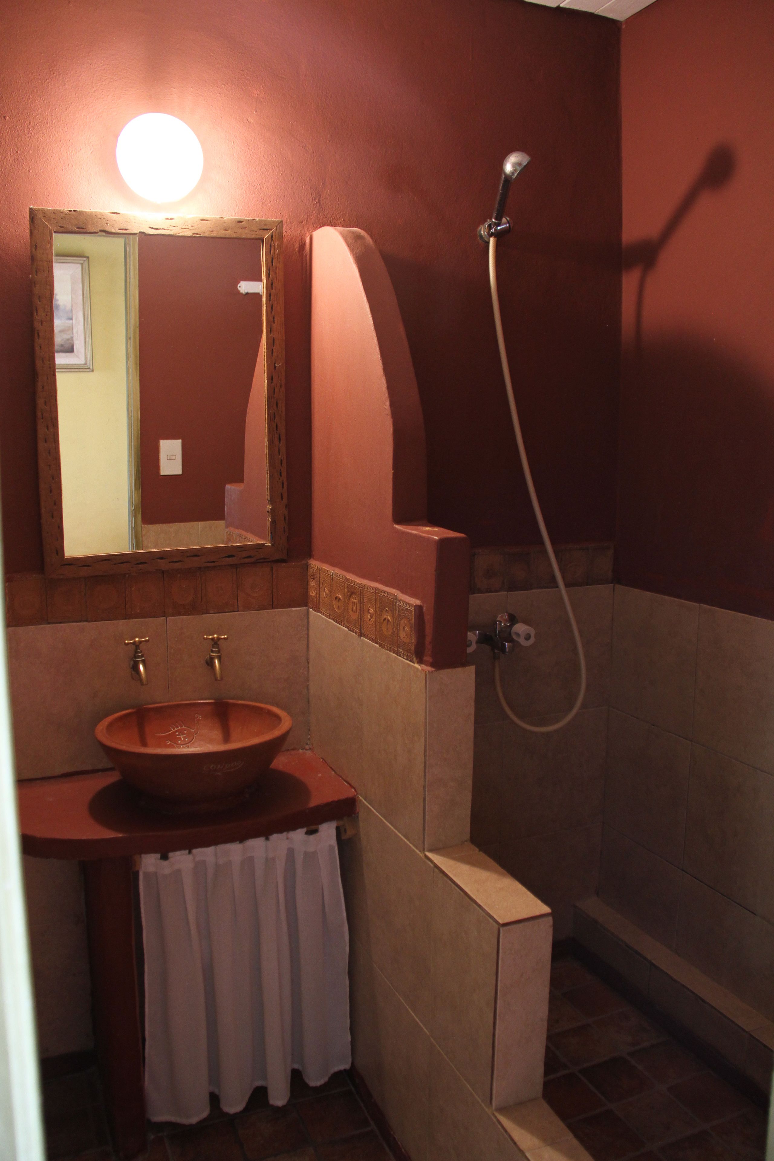 A bathroom with a wooden sink, a mirror, and a shower.
