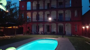 Una piscina al aire libre, sillones reclinables de piscina