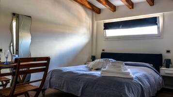 Ein Schlafzimmer mit Bett, Stuhl, Schreibtisch und Fenster.