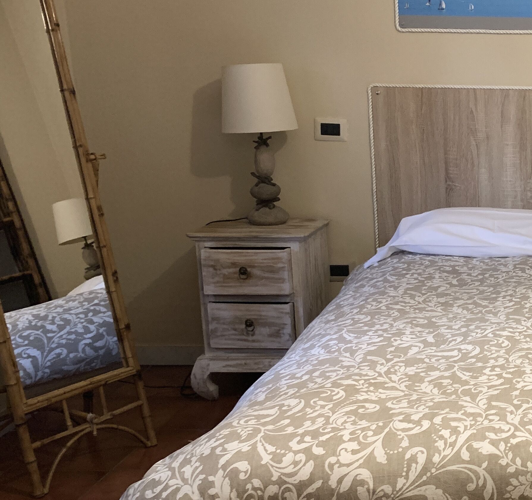 A bedroom with a bed, a nightstand with a lamp, and a wooden ladder.