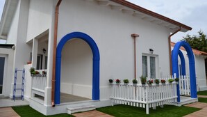 Um edifício branco com arcos azuis e uma cerca branca de piquete.