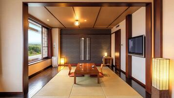 Ein traditioneller japanischer Raum mit Tatami-Bodenbelag, einem niedrigen Holztisch und Schiebetüren.