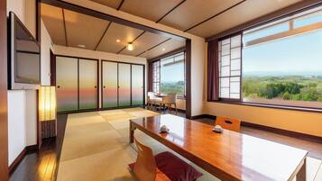 Una habitación tradicional japonesa con suelo de tatami, una mesa de madera y puertas correderas.