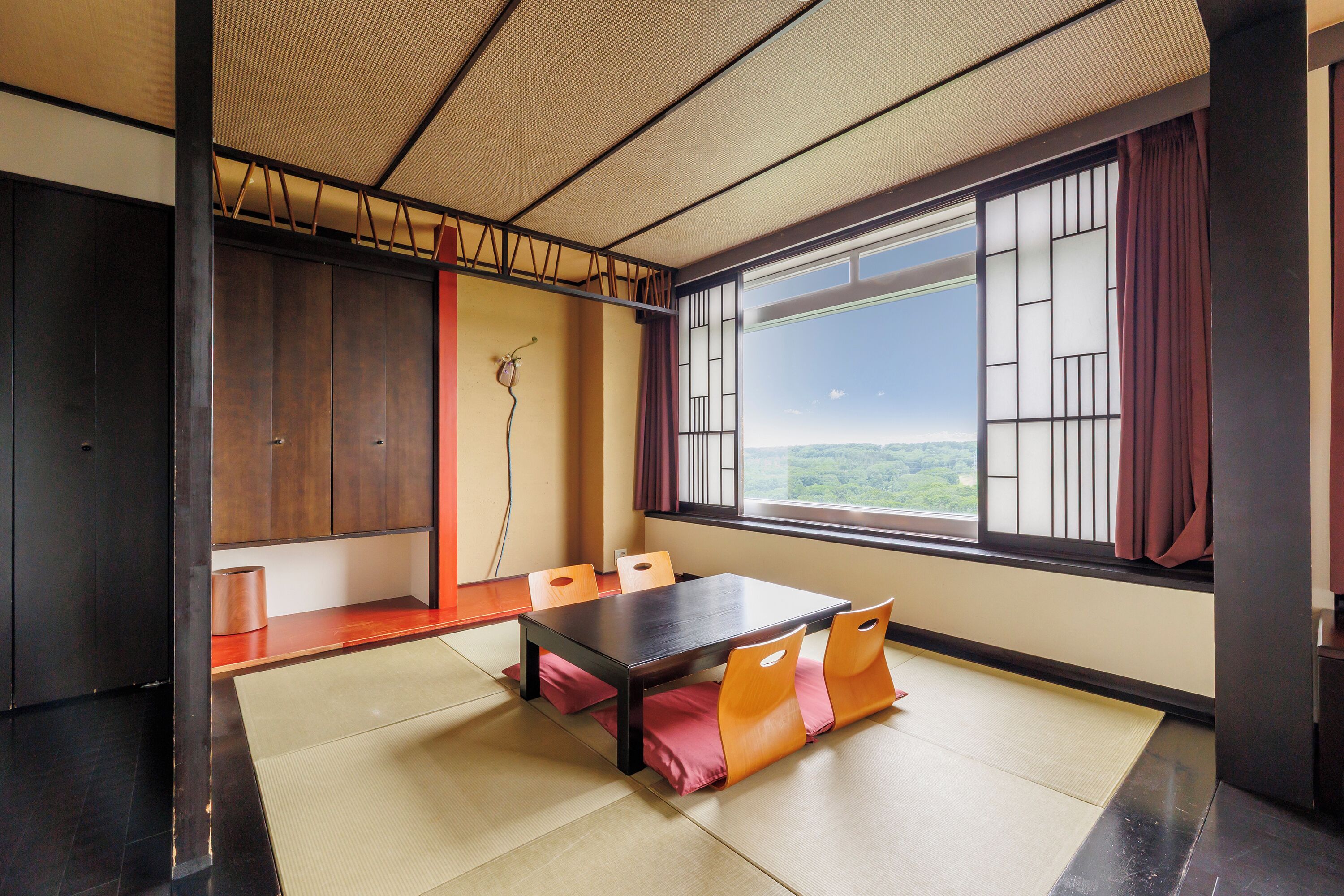 Una habitación japonesa tradicional con suelo de tatami, una mesa baja y puertas correderas.