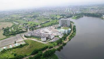 An industrial area with a large parking lot, a river, and a bridge in the background.