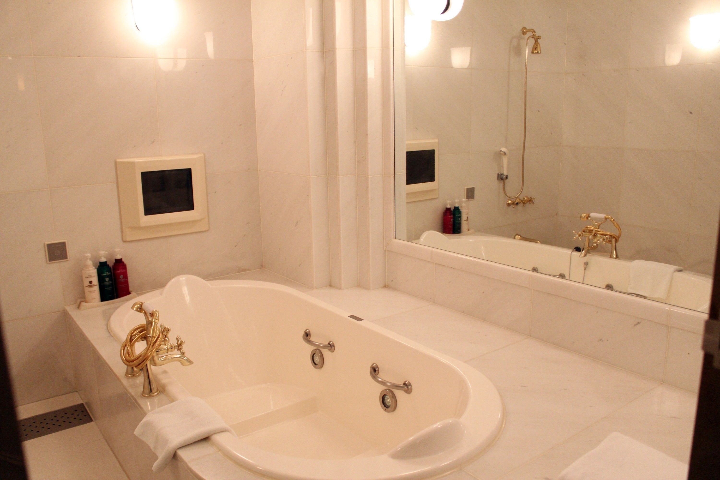 A modern bathroom with a freestanding bathtub, a large mirror, and a shower area.
