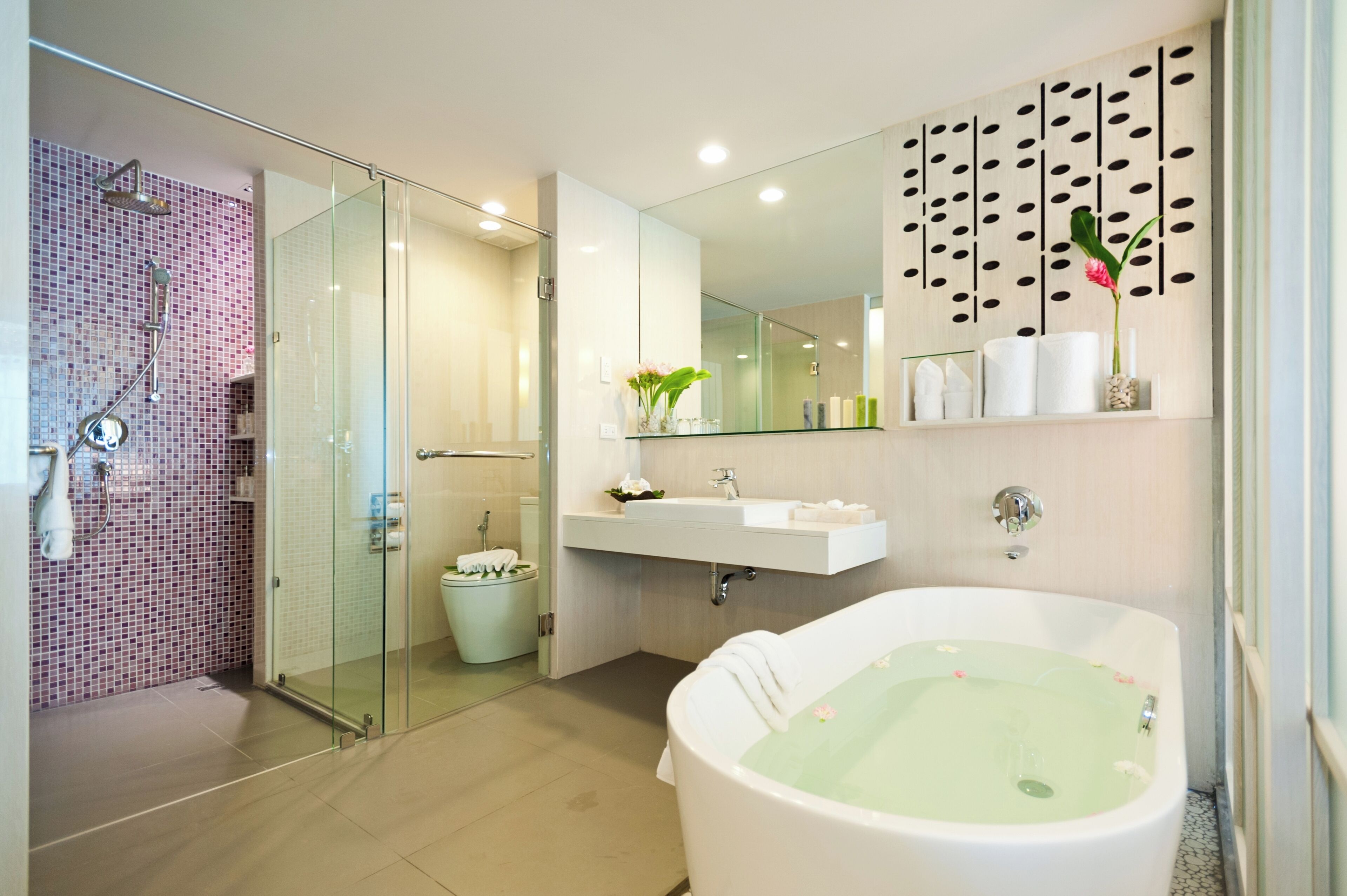 A modern bathroom with a glass-enclosed shower, a freestanding bathtub, and a vanity with a mirror and sink.