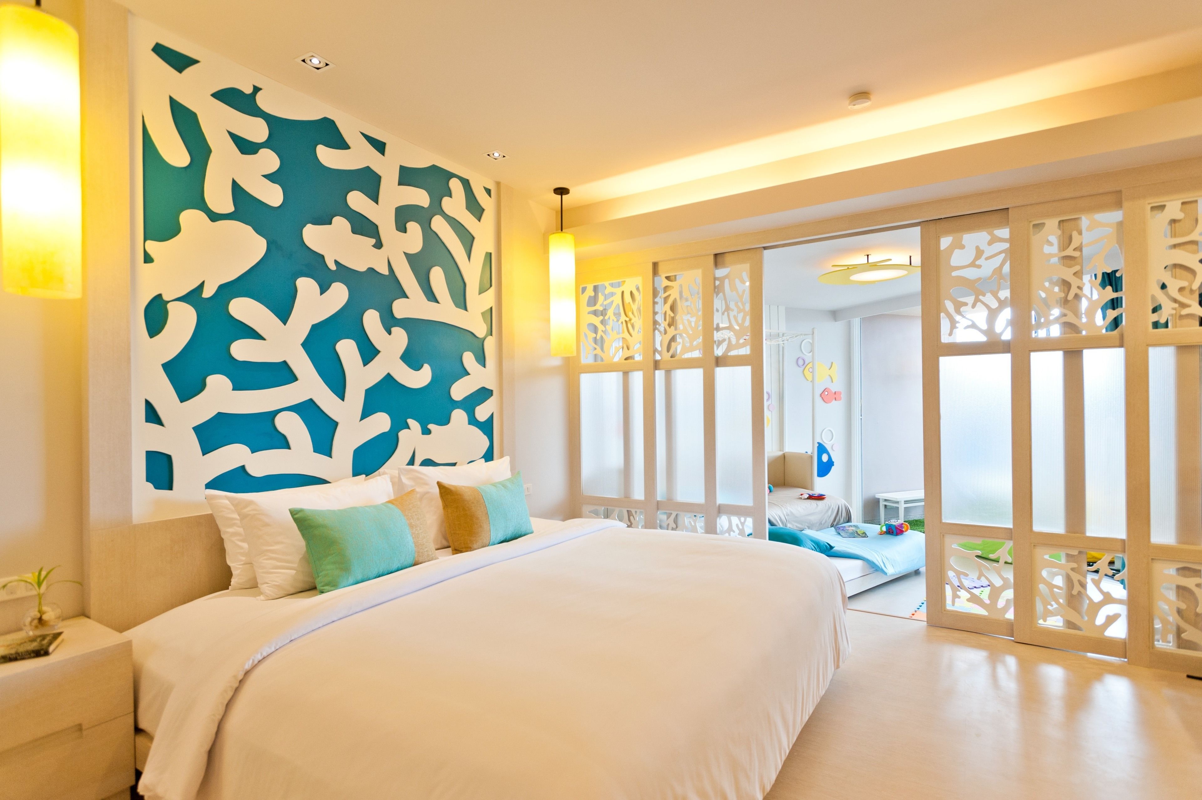 Una habitación de hotel moderna con una cama grande, un muro decorativo y un divisor corredizo que da a un balcón.