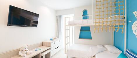 Un dormitorio infantil con literas, un televisor, un escritorio y una ventana.