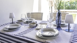 A table set for dining with plates, glasses, and a vase. - Las Brisas I & II (Ciutadella de Menorca)