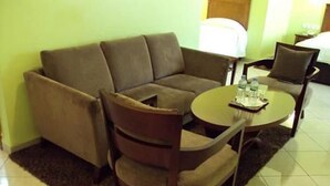A living room with a sofa, a chair, and a coffee table. - Hotel Sweet (Algiers)