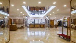A spacious lobby with a high ceiling, a reception desk, and a seating area. - Eden Phoenix (El Kerma)