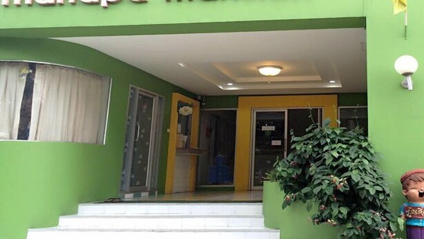 A building entrance with a sign reading "Thanapa Mansion".