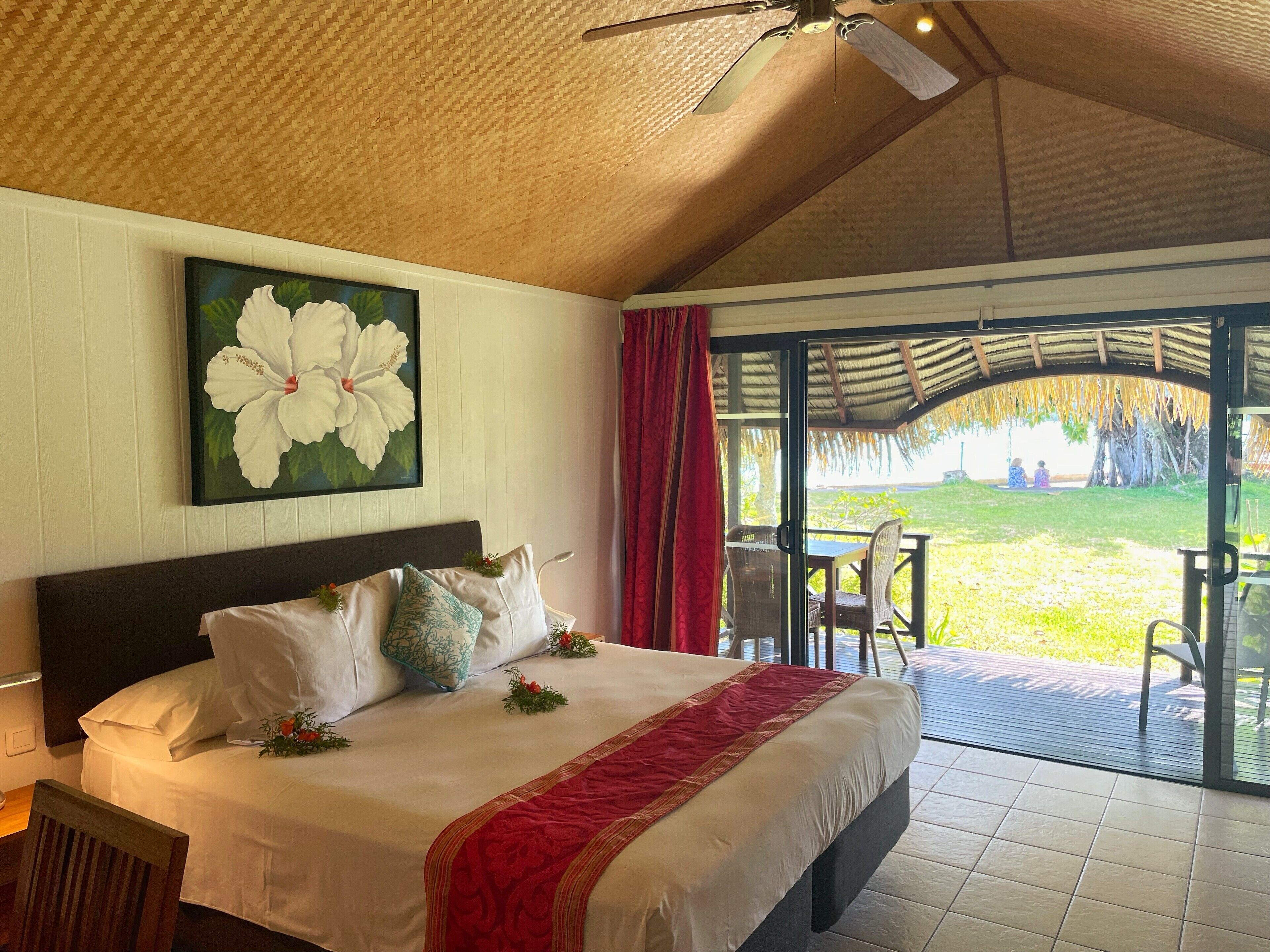 A hotel room with a bed, a large window, and a view of the outdoors.