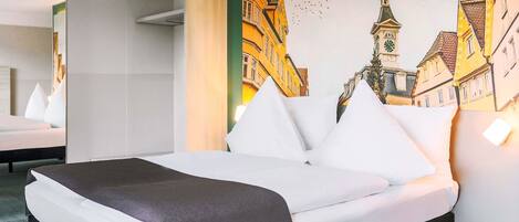 Una habitación de hotel con una cama, un cuadro grande de un paisaje urbano y un espejo que refleja la habitación.