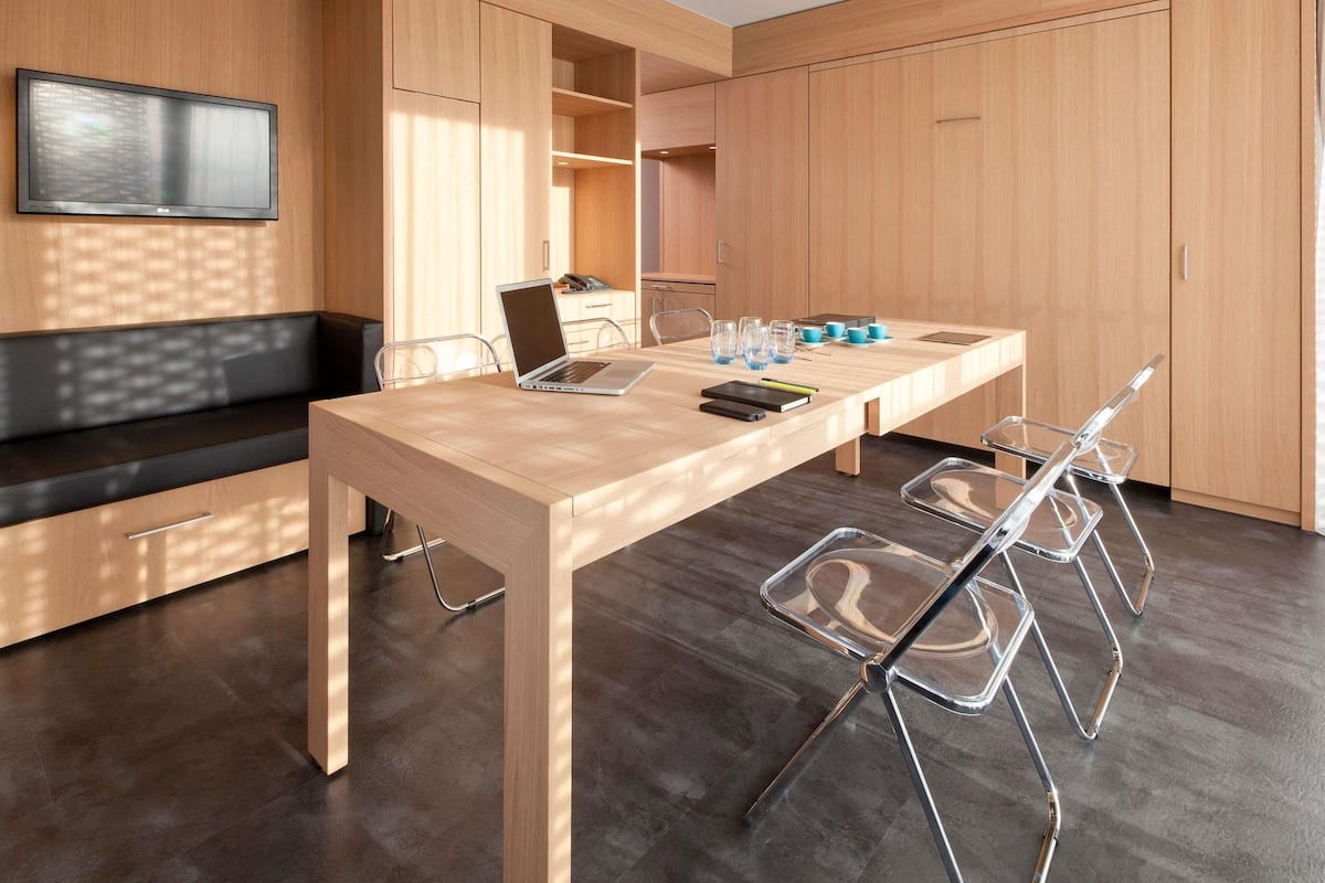 Une cuisine moderne avec des meubles en bois, une table à manger et un ordinateur portable.