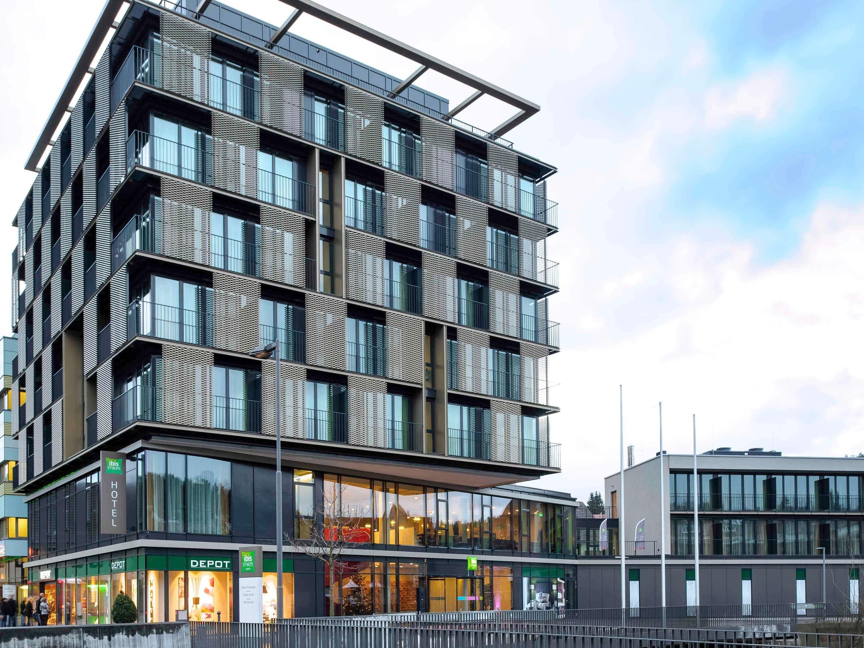 A modern hotel with a multi-story structure, large windows, and a flat roof.