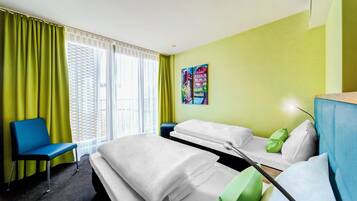 Relax in a spacious room with a large bed, desk, and comfortable chair.