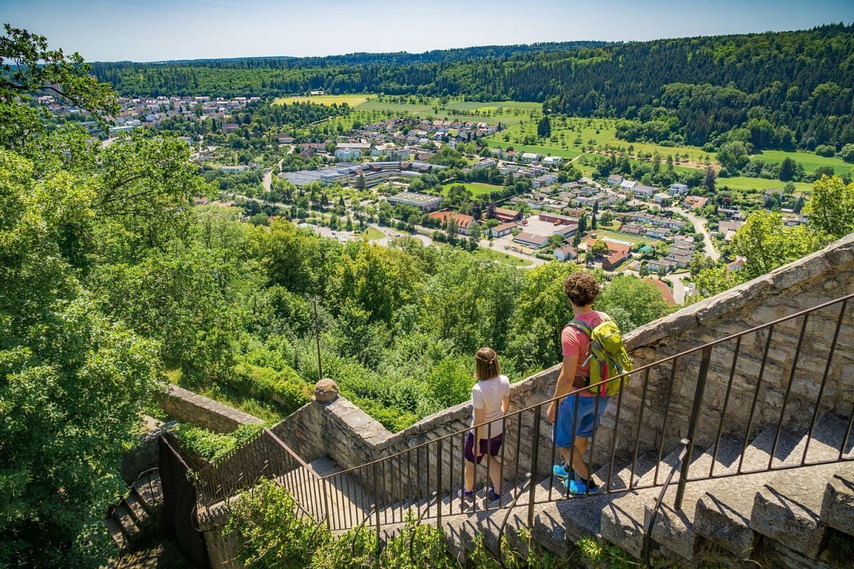 A scenic overlook with a stone staircase leading down to a town below.