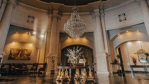 A grand lobby with a high ceiling, a chandelier, and a central reception desk. - Azul Talavera Country Club (Torreón)
