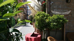 A street view with a cafe named 'Caffe Del Corso Ristorante Pizzeria' and a red table with a menu stand. - La Pergola (Castellabate)