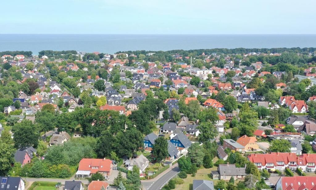 Un barrio residencial con casas, árboles y vistas al mar.