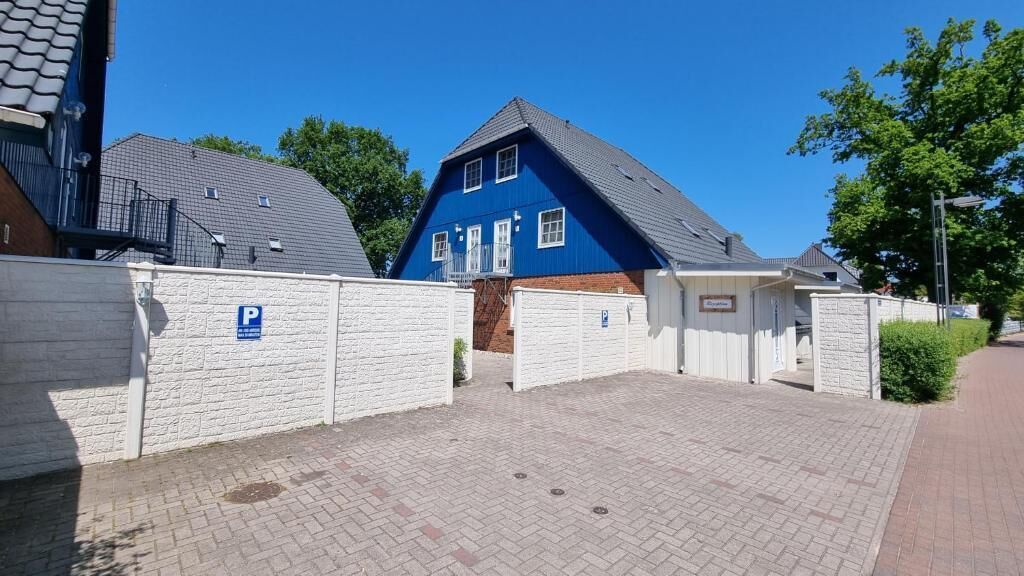 Een afgesloten parkeerplaats met een blauw huis op de achtergrond.