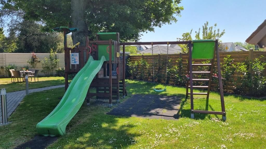 Une aire de jeux avec un toboggan et des structures d’escalade.