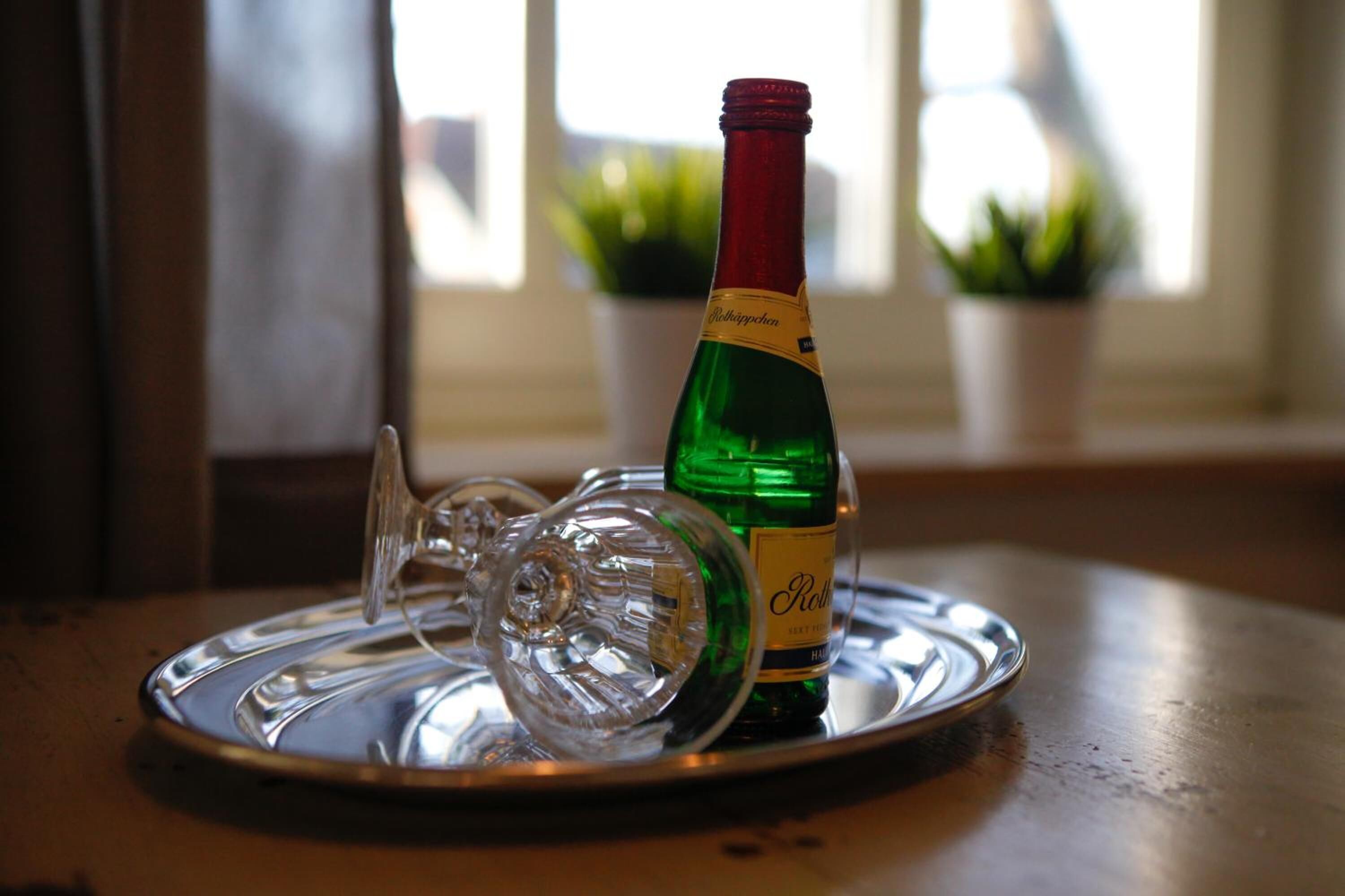 A bottle of champagne on a tray with a glass.