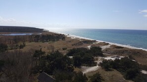 A coastal landscape with a beach, a small body of water, and sparse vegetation. - Captain Pahlen Ferienanlage (Zingst)