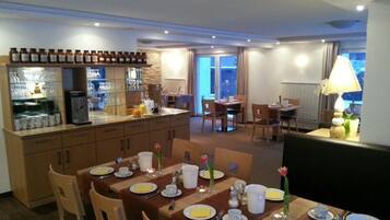 Un comedor de hotel con una isla central, una mesa separada y un conjunto de asientos.