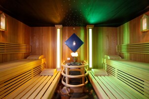 Un sauna avec des bancs en bois et un pilier central.