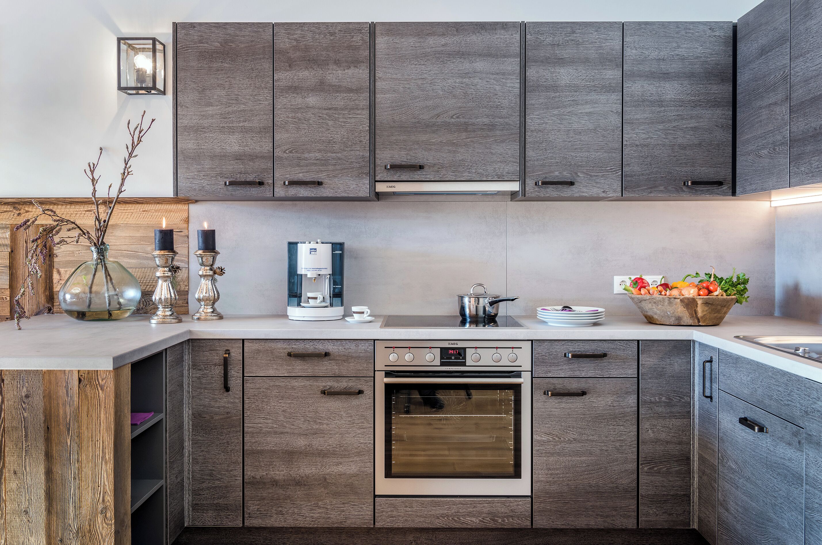 Una cocina moderna con armarios de madera, horno empotrado, cafetera y frutero.