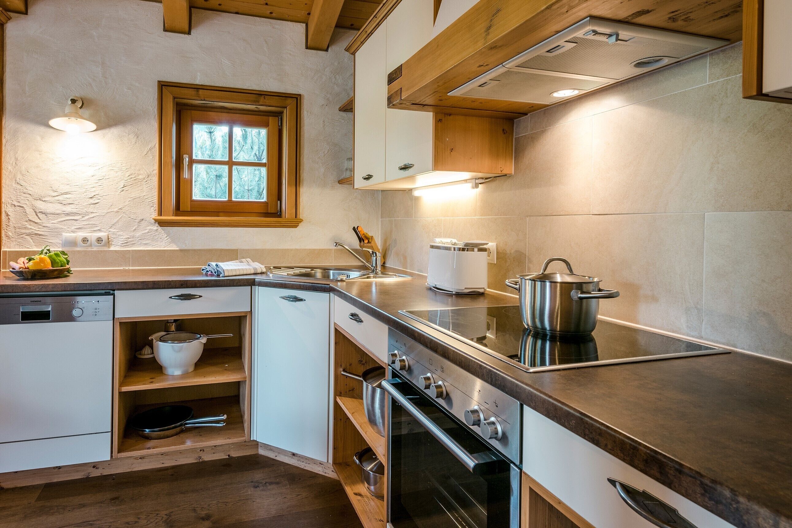 Una cocina moderna con electrodomésticos integrados, armarios de madera y un ventanal con vistas.