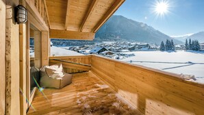 A wooden cabin with a balcony overlooking a snowy landscape and mountains. - Almdorf Almlust (Flachau)