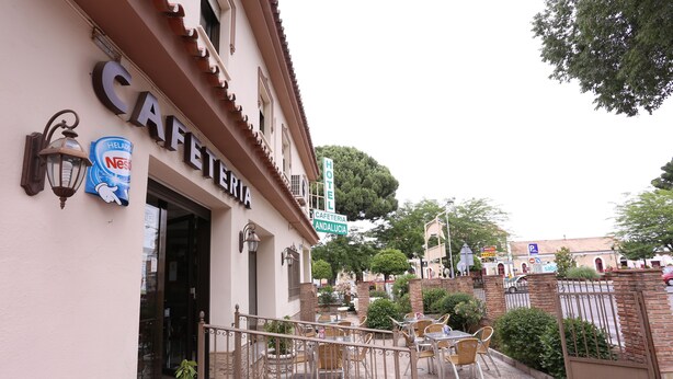 Un café con terraza, un letrero de Nestlé y un letrero de hotel.