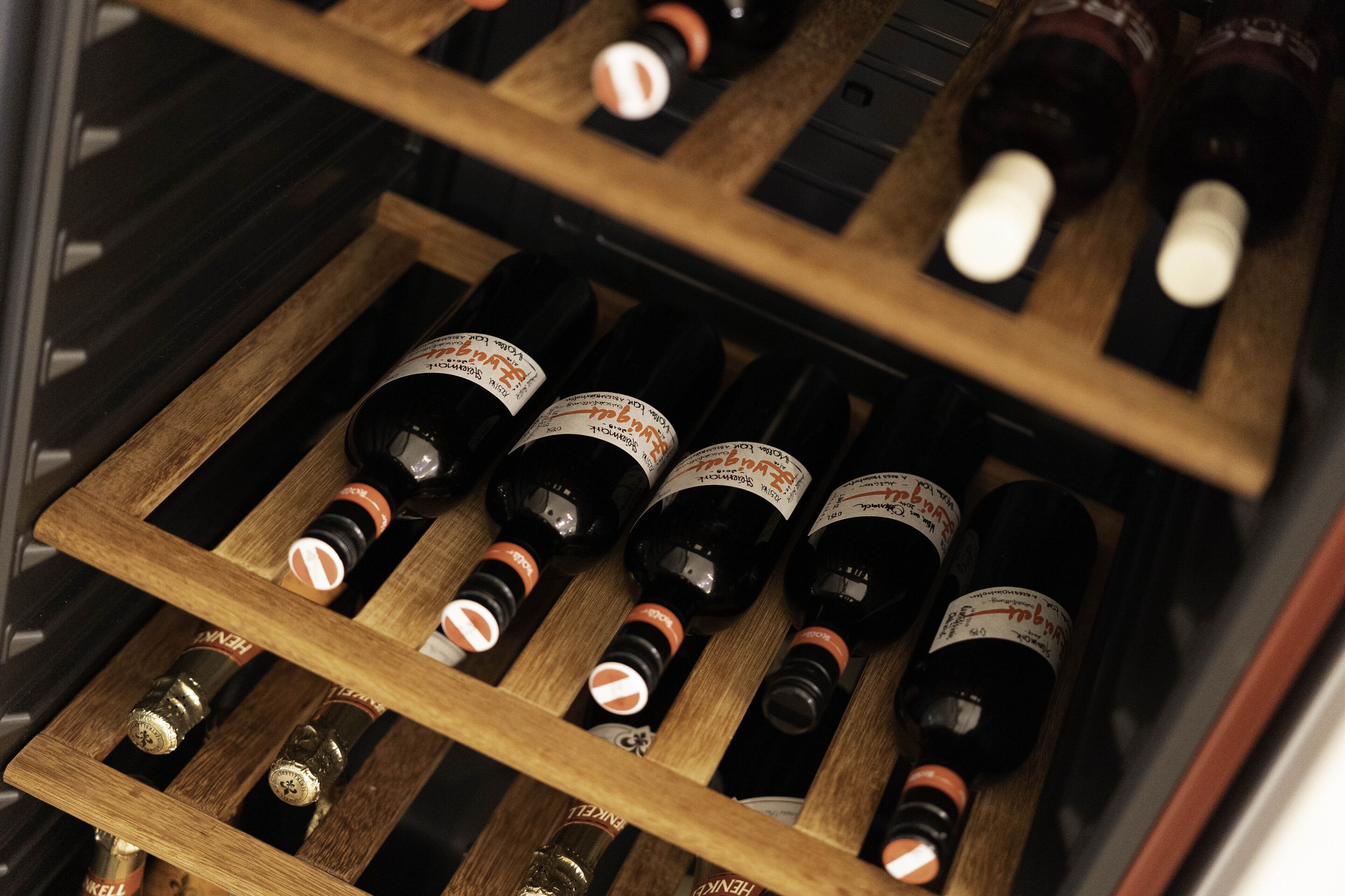 A wooden wine rack with bottles of wine.