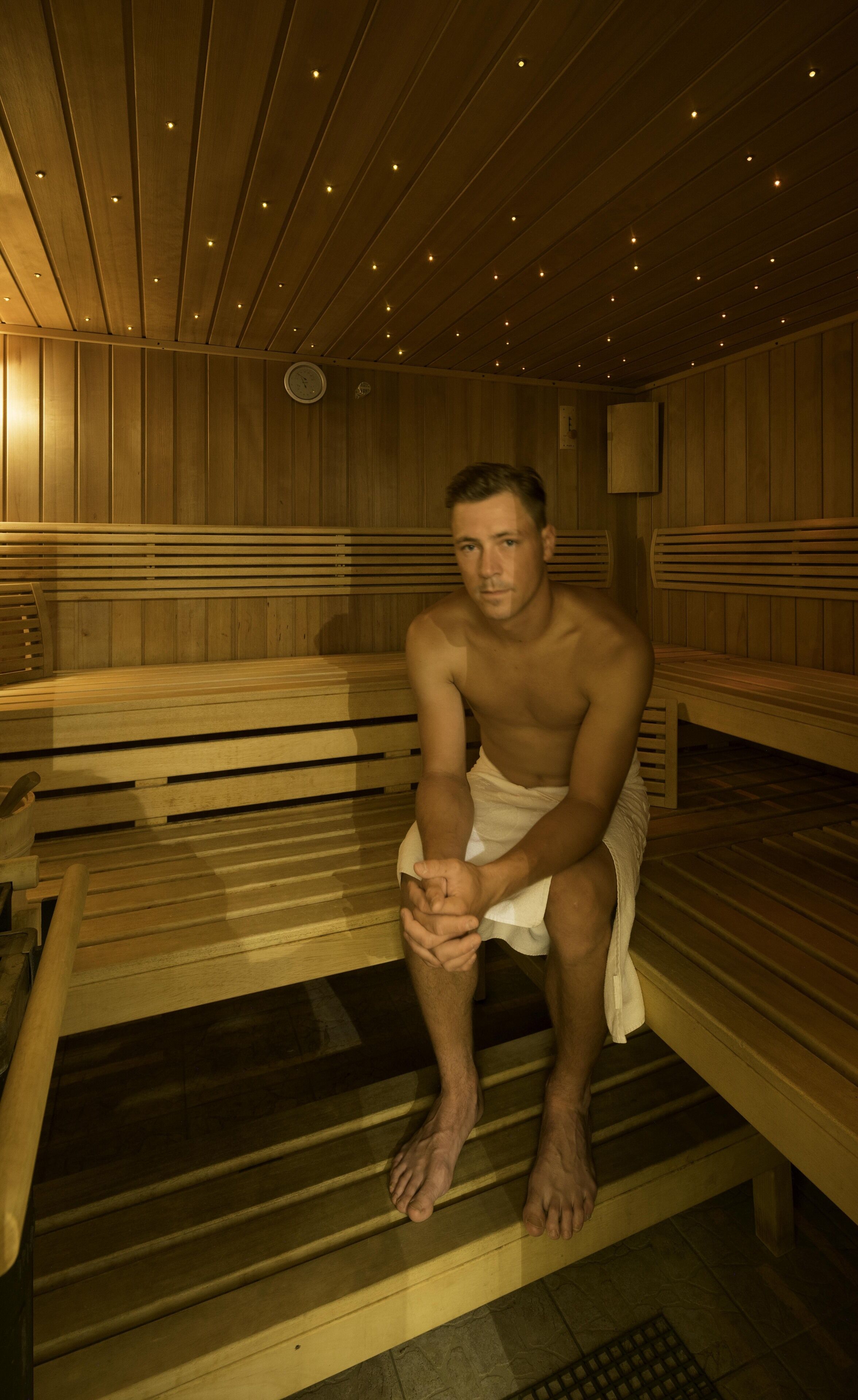 Una sauna con bancos de madera y suelo de baldosas.
