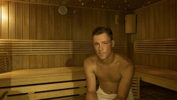Una sauna con bancos de madera y suelo de baldosas.