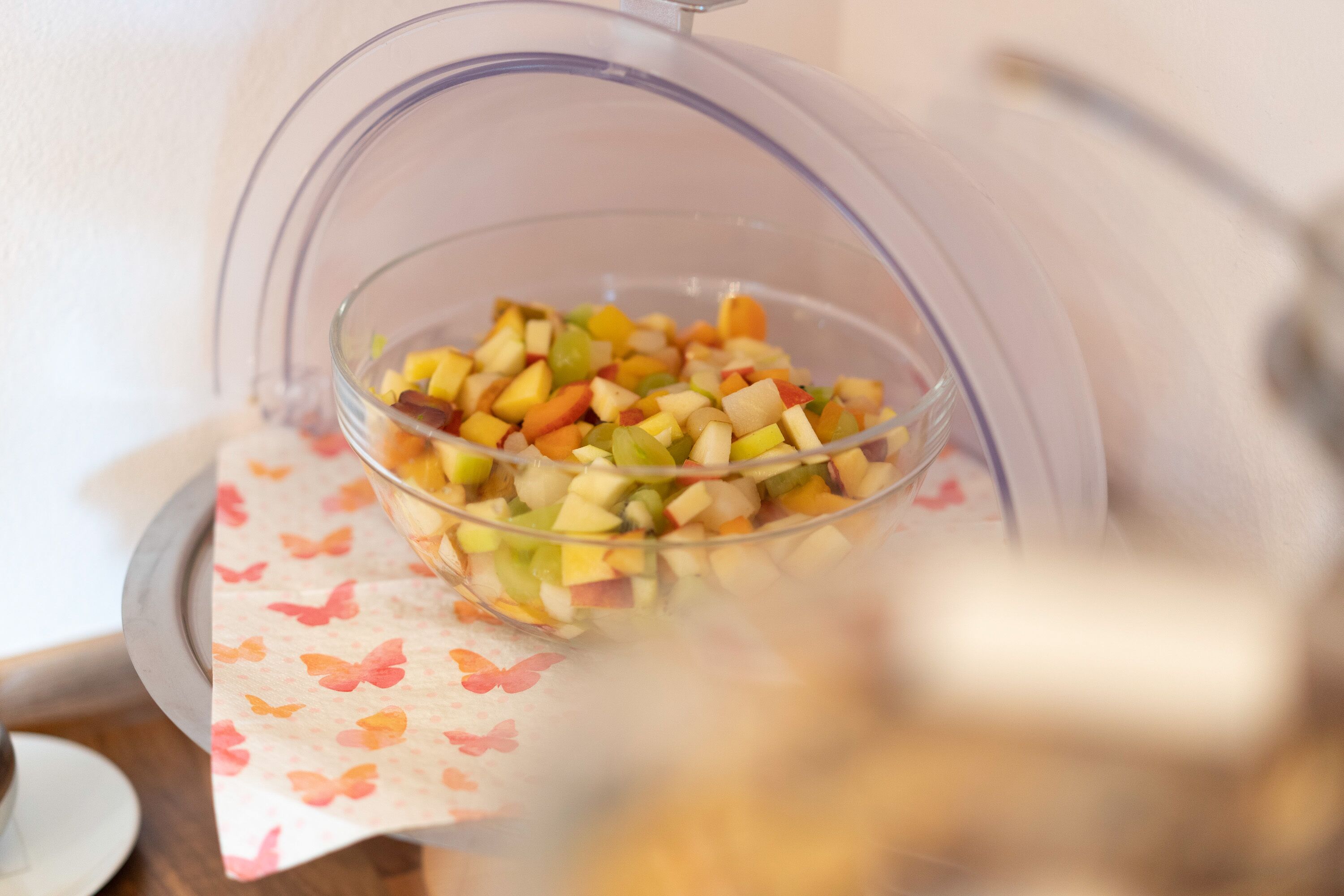 Un procesador de alimentos con frutas picadas sobre una mesa.