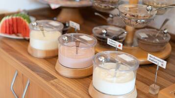 Una mesa de buffet con varios recipientes de yogur etiquetados en distintos idiomas.