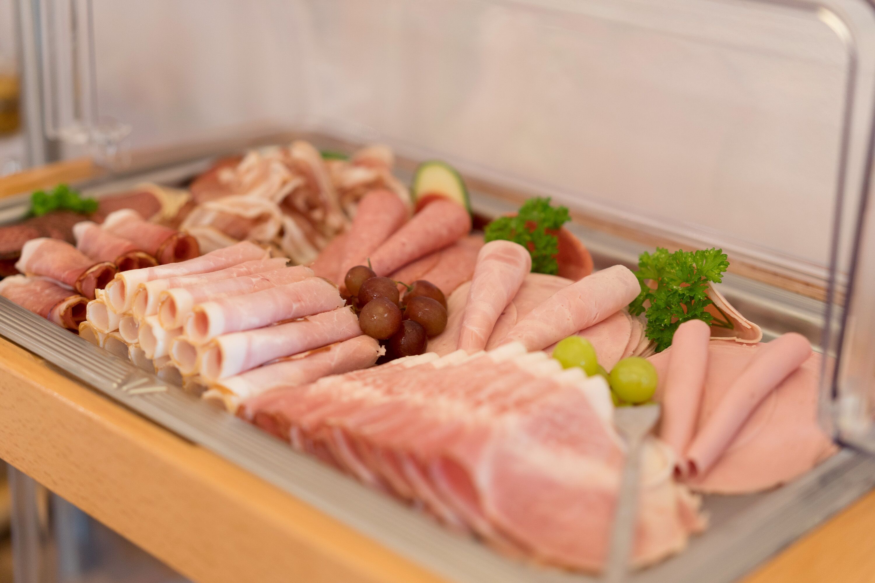 A buffet with various meats and garnishes.