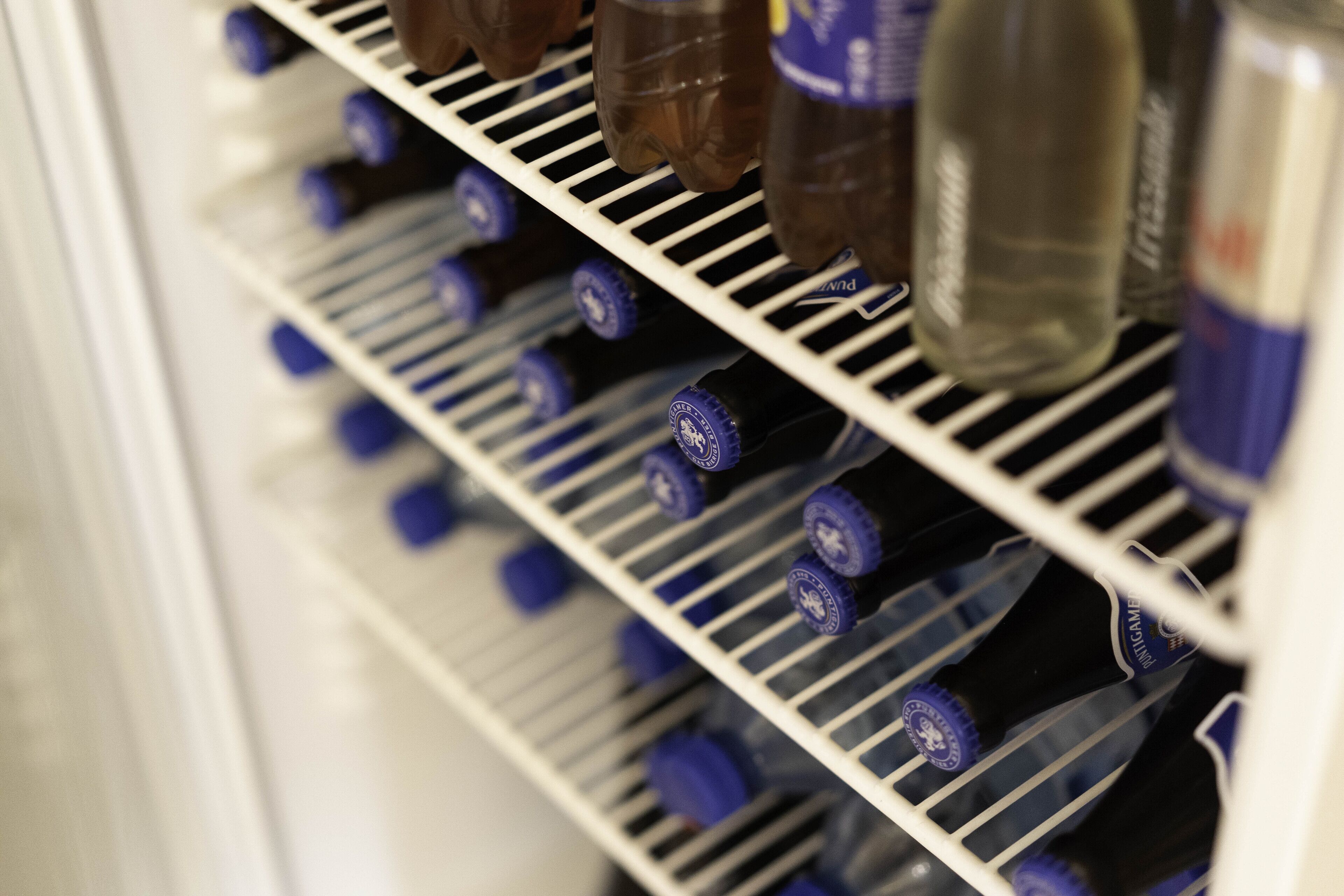 Un refrigerador lleno de bebidas embotelladas.